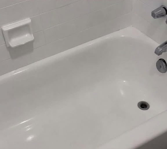 After cleaning: a bathtub with a plunger and visible grime